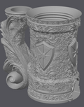 Decorative tankard with intricate designs and a shield emblem on a gray background